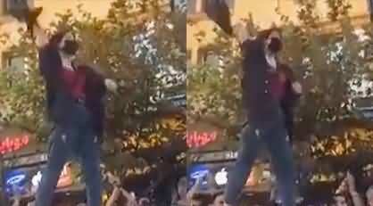 Iranian girl waves a hijab on top of a car during a protest in Mashad, in northeast Iran